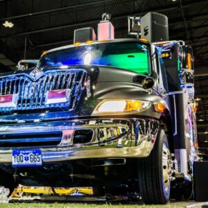 A customized truck with a glossy finish and added technological trivia equipment on display at an indoor exhibition.