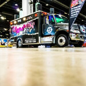 A black tow truck with colorful decals advertising 