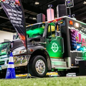 A colorful, customized jammin' 98.3 radio station truck with vibrant graphics and enhanced lighting, featured at a trivia night event.